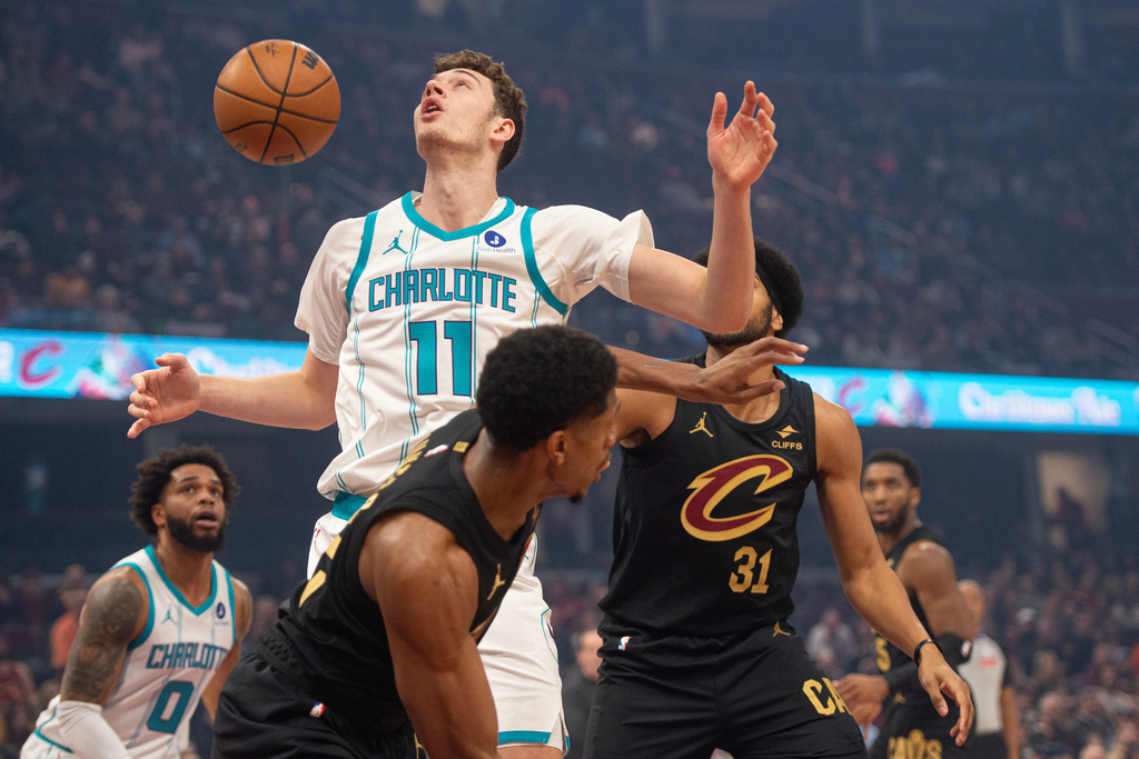 Charlotte Hornets' Ryan Kalkbrenner (11) cannot control the ball as Cleveland Cavaliers' De'Andre Hunter, front, and Jarrett Allen (31) defend during the first half of an NBA basketball game in Cleveland, Sunday, Dec. 14, 2025. (AP Photo/Phil Long)