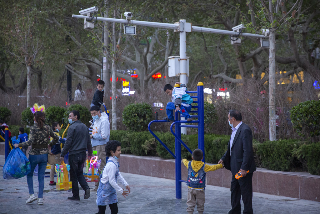 FILE - Children play on a playground near security cameras at a public square in Aksu, in western China's Xinjiang Uyghur Autonomous Region, Tuesday, April 20, 2021. (AP Photo/Mark Schiefelbein, File)