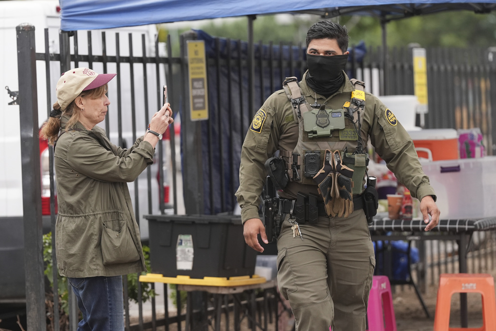 A U.S. Customs and Border Protection agent is filmed during an operation outside a Home Depot Friday, Aug. 15, 2025, in Los Angeles. (AP Photo/Gregory Bull)