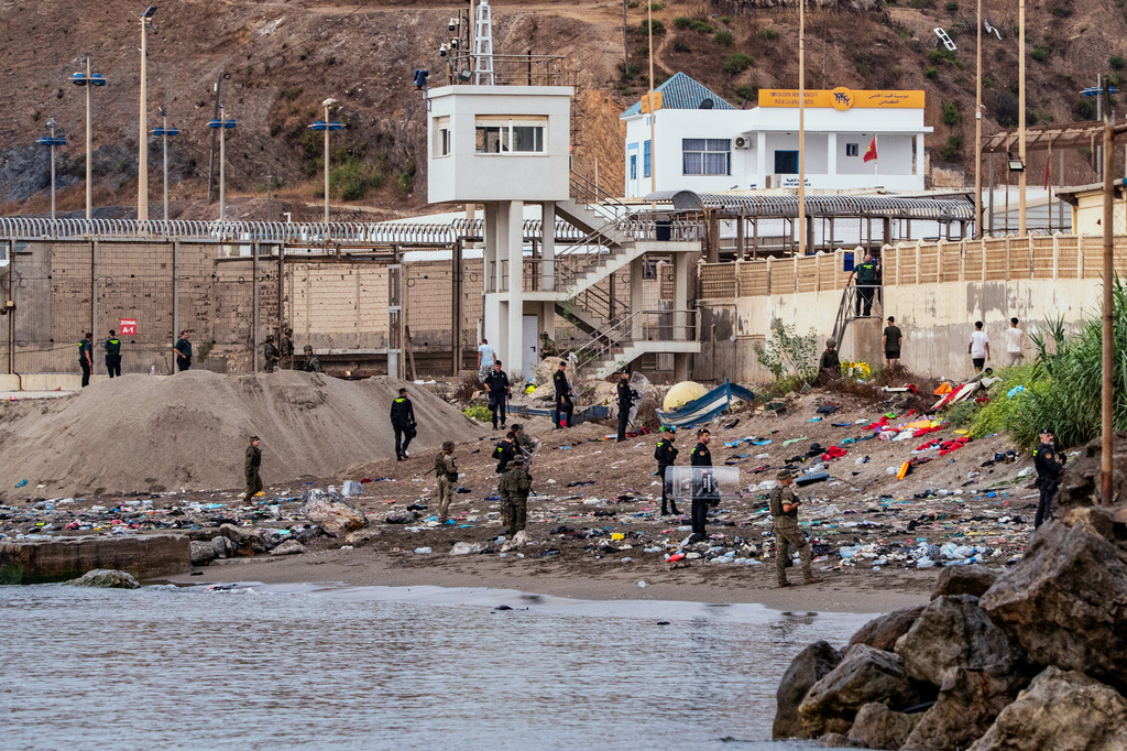 Spanish army soldiers and Guardia Civil officers stand guard as migrants return to Morocco from the Spanish enclave of Ceuta, Saturday, Aug. 1, 2026. (AP Photo/Antonio Sempere)