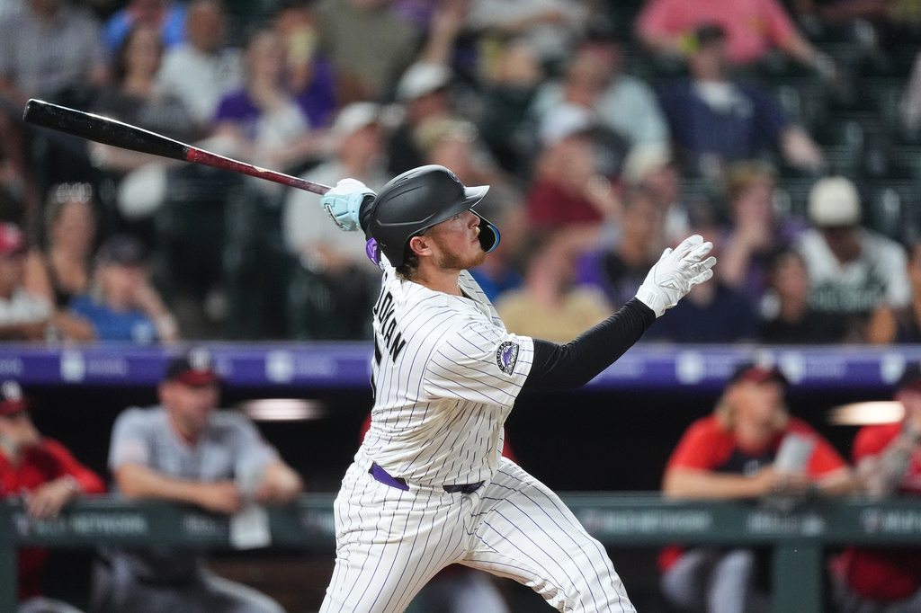 Colorado Rockies' Hunter Goodman follows the flight of his solo home run off Washington Nationals relief pitcher Clayton Beeter in the eighth inning of a baseball game Tuesday, July 21, 2026, in Denver. (AP Photo/David Zalubowski)
