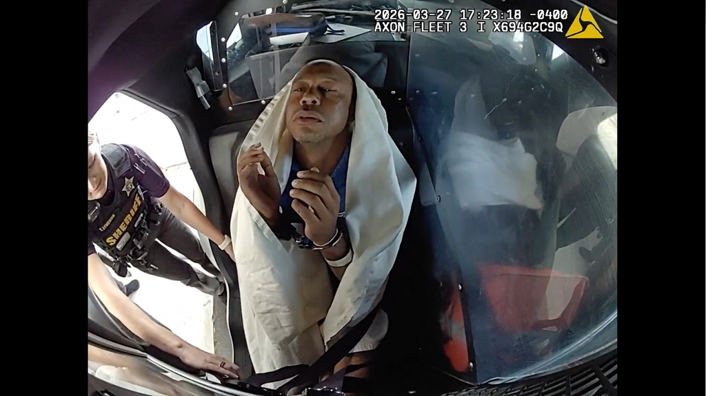 In this image from video provided by the Martin County, Fla., Sheriff's Office, golfer Tiger Woods is strapped into a police vehicle following a car crash in Jupiter Island, Fla., Friday, March 27, 2026. (Martin County Sheriff's Office via AP)