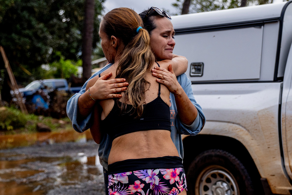 Linda Griffith, left, embraces neighbor Frankie, the day after a fast-moving flood damaged much of their neighborhood in Haleiwa, Hawaii Saturday, March 21, 2026. (Stephen Lam/San Francisco Chronicle via AP)