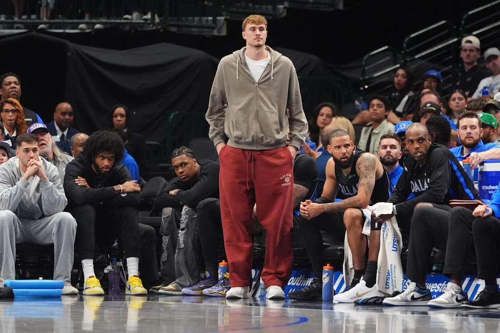 An injured Dallas Mavericks forward Cooper Flagg stands and looks on from the bench during the second half of an NBA basketball game against the Oklahoma City Thunder in Dallas, Sunday, March 1, 2026. (AP Photo/LM Otero)