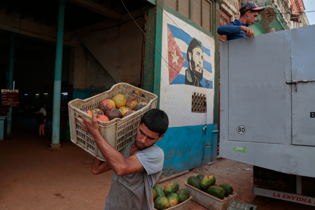 A worker unloads boxes of fruit at a state-run market in Havana, Cuba, Wednesday, June 17, 2026. (AP Photo/Jorje Luis Banos)