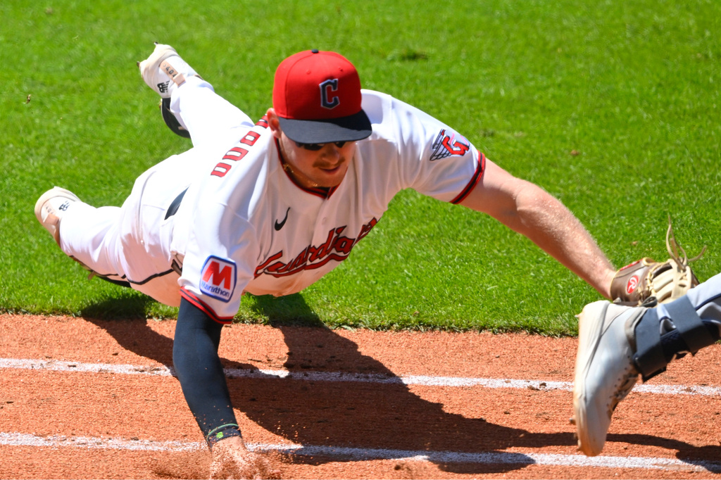 Cleveland Guardians first baseman Kyle Manzardo, left, dives to tag out Seattle Mariners' Cole Young, right, during the fifth inning of a baseball game, Sunday, June 28, 2026, in Cleveland. (AP Photo/David Richard)