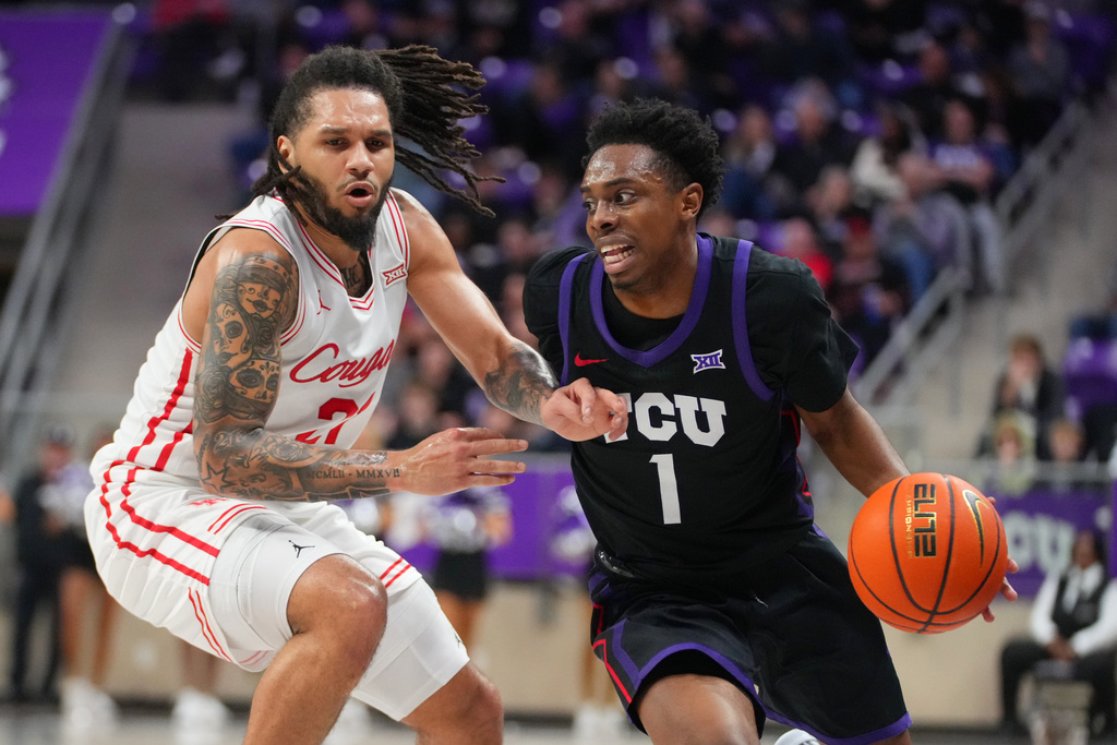 TCU guard Jayden Pierre (1) drives against Houston guard Emanuel Sharp during the first half of an NCAA college basketball game Wednesday, Jan. 28, 2026, in Fort Worth, Texas. (AP Photo/Julio Cortez)