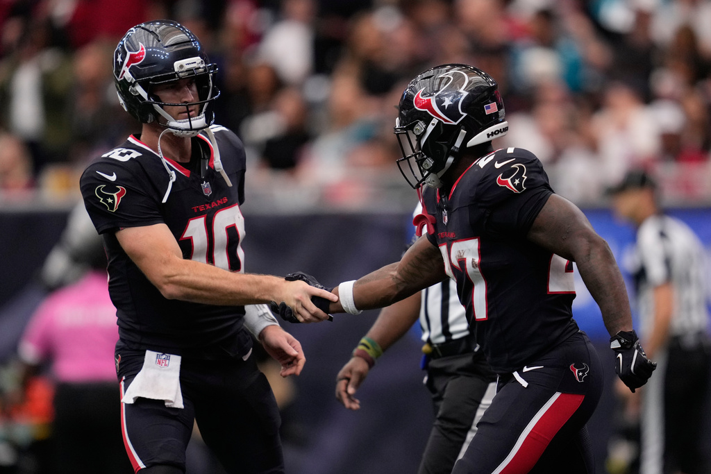 Houston Texans quarterback Davis Mills (10) celebrates with Houston Texans running back Woody Marks (27) during an NFL football game, Sunday, Nov. 9, 2025, in Houston. (AP Photo/Ashley Landis)