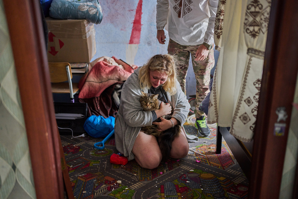 Liudmyla Ryzhak, bottom, and her fiancee Leonid Ryzhak found their lost cat in their damaged apartment following a Russian missile and drone attack in Kyiv, Ukraine, early Tuesday, Sept. 8, 2026, as they get ready for their wedding ceremony. (AP Photo/Francisco Seco)