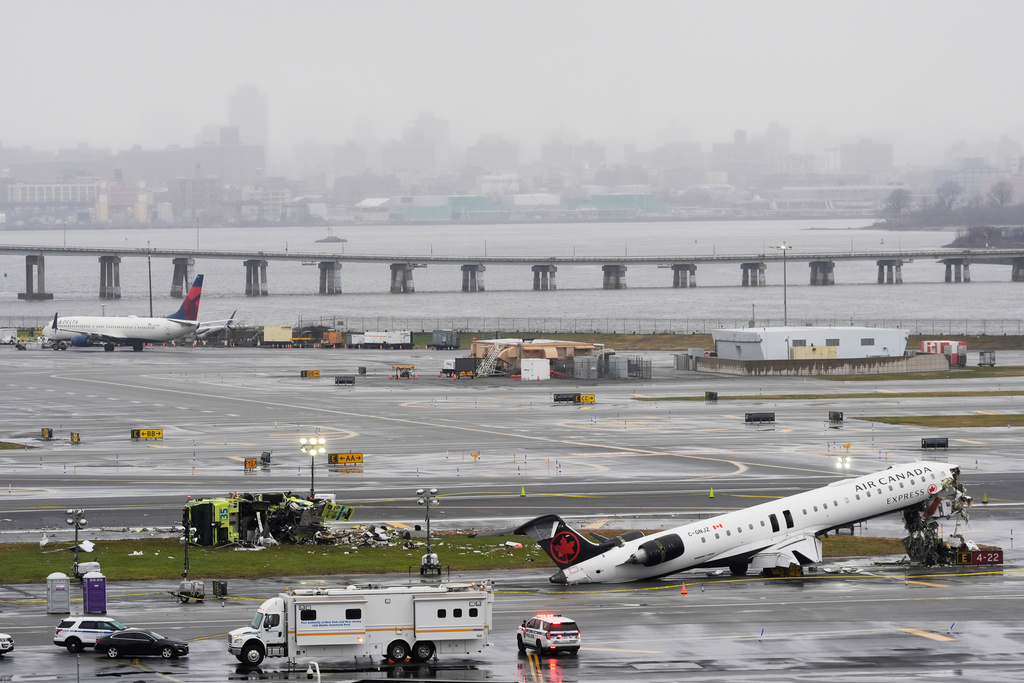 An Air Canada jet and Port Authority fire truck sit on the runway at LaGuardia Airport, Monday, March 23, 2026, after colliding with each other after the jet landed Sunday night in New York. (AP Photo/Seth Wenig)