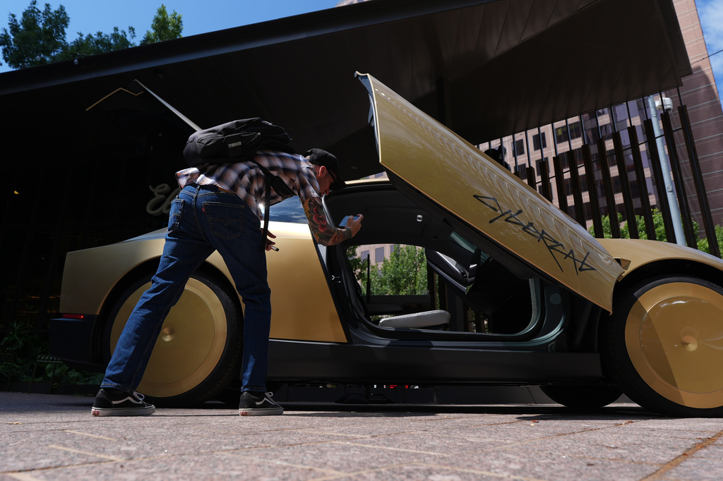 A man photographs a Tesla Cybercab on display in downtown Austin, Texas, Thursday, Sept. 3, 2026. (AP Photo/Eric Gay)