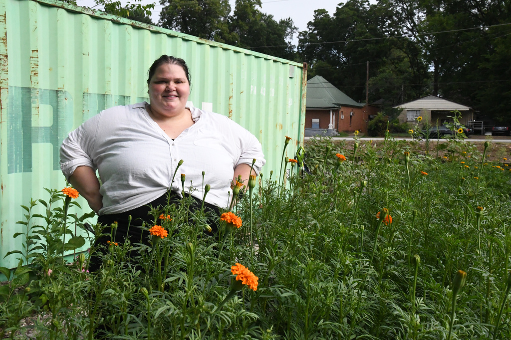 Marisa Mender-Franklin poses for a picture on Thursday, July 23, 2026, in one of the properties that she crowdsourced for free to plant flowers for her florist shop in Memphis, Tenn. (AP Photo/Kristin M. Hall)