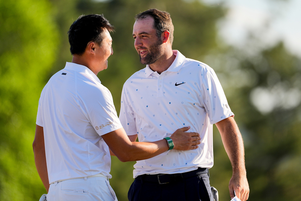 Haotong Li, of China, greets Scottie Scheffler after their final round of the Masters golf tournament at the Augusta National Golf Club, Sunday, April 12, 2026, in Augusta, Ga. (AP Photo/David J. Phillip)