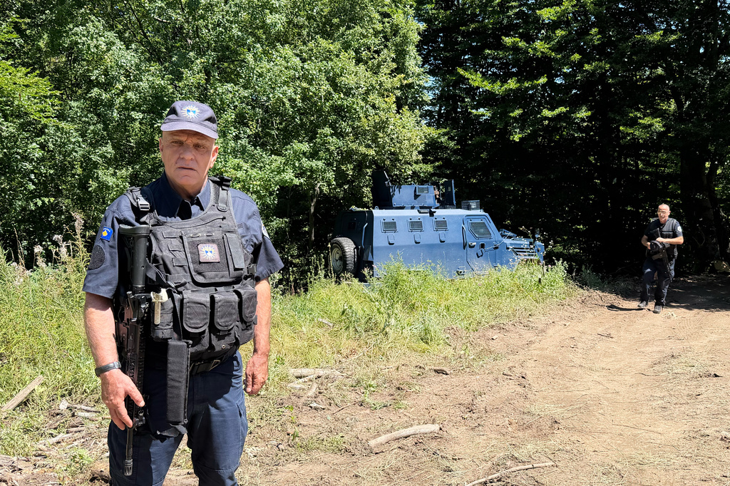 A Kosovo policemen guards the site where forensic teams have begun excavations of a mass grave near the village of Kalluder, Wednesday, July 29, 2026. (AP Photo/Florent Bajrami)