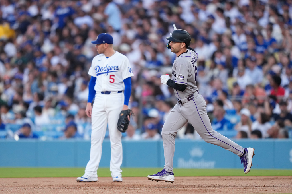 Colorado Rockies' Edouard Julien, right, heads to second for a solo home run as Los Angeles Dodgers first baseman Freddie Freeman stands by during the second inning of a baseball game Wednesday, July 8, 2026, in Los Angeles. (AP Photo/Mark J. Terrill)
