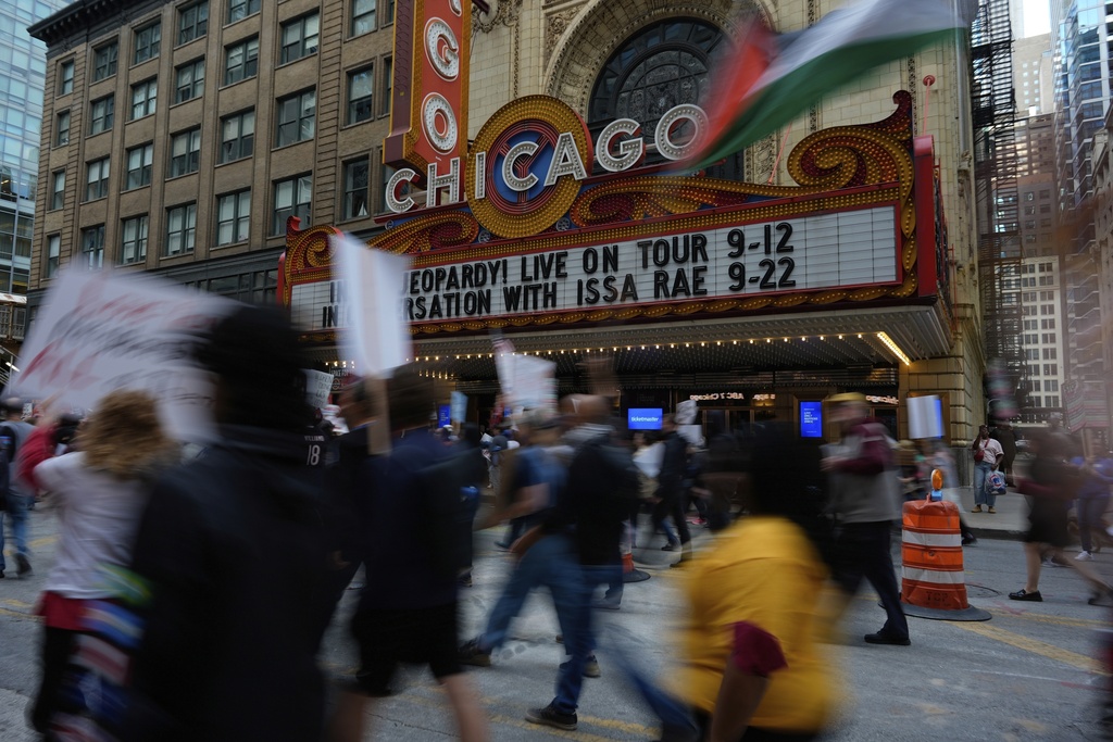 People march by Chicago Theater during Illinois Coalition for Immigrant & Refugee Rights' "Chicago Says No Trump No Troops" protest Saturday, Sept. 6, 2025, in Chicago. (AP Photo/Carolyn Kaster)