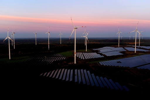 FILE - Wind turbines operate as the sun rises at the Klettwitz Nord solar energy park near Klettwitz, Germany, Oct. 16, 2024. (AP Photo/Matthias Schrader, File) FILE - Wind turbines operate as the sun rises at the Klettwitz Nord solar energy park near Klettwitz, Germany, Oct. 16, 2024. (AP Photo/Matthias Schrader, File)