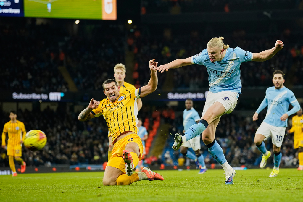 Manchester City's Erling Haaland, right, attempts a shot at goal in front of Brighton's Lewis Dunk during the English Premier League soccer match between Manchester City and Brighton and Hove Albion in Manchester, England, Wednesday, Jan. 7, 2026. (AP Photo/Dave Thompson)