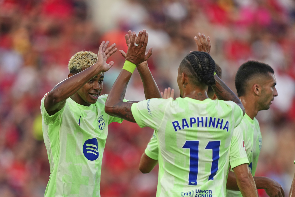 Barcelona's Lamine Yamal left, and Raphinha celebrate after a goalduring the La Liga soccer match between Mallorca and Barcelona in Mallorca, Spain, Saturday, Aug. 16, 2025. (AP Photo/Joan Mateu Parra)