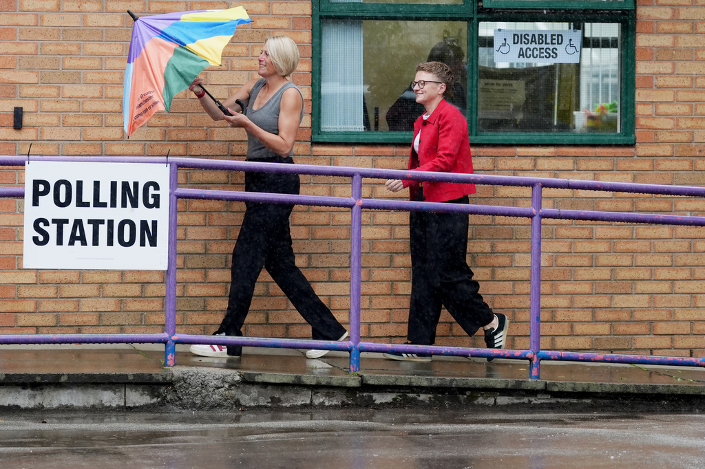 Bev Craig, the Labour Party candidate, centre right, arrives with her partner Tracy at Broad Oak Primary, in Didsbury, to vote in the Greater Manchester mayoral by-election, in Manchester, England, Thursday July 30, 2026. (Annabelle Lee-Ellis/PA via AP)