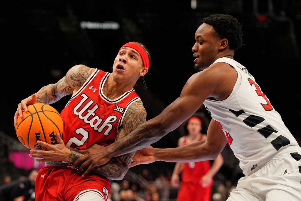 Cincinnati guard Jalen Celestine, right, tries to steal the ball from Utah guard Terrence Brown (2) during the first half of an NCAA college basketball game at the Big 12 Conference tournament Tuesday, March 10, 2026, in Kansas City, Mo. (AP Photo/Charlie Riedel)