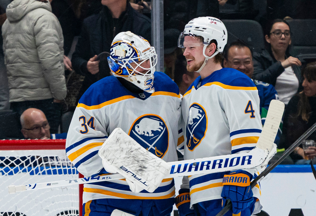 Buffalo Sabres goalie Alex Lyon, left, and Bowen Byram share a laugh after defeating the Vancouver Canucks in an NHL hockey game in Vancouver, British Columbia, on Thursday, Dec. 11, 2025. (Rich Lam/The Canadian Press via AP)