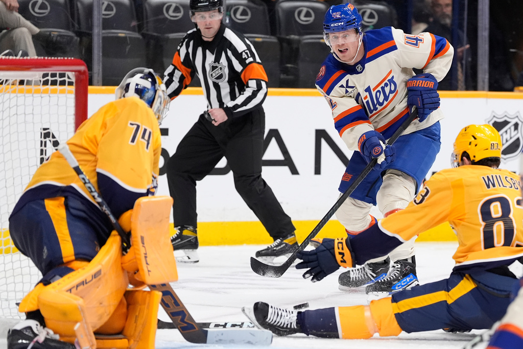 Edmonton Oilers right wing Kasperi Kapanen (42) has his shot on goal blocked by Nashville Predators defenseman Adam Wilsby (83) and goaltender Juuse Saros (74) during the third period of an NHL hockey game Tuesday, Jan. 13, 2026, in Nashville, Tenn. (AP Photo/George Walker IV)