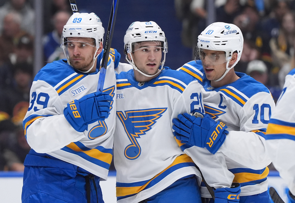From left to right, St. Louis Blues' Pavel Buchnevich, Jimmy Snuggerud and Brayden Schenn celebrate after Snuggerud's second goal against the Vancouver Canucks, during the second period of an NHL hockey game in Vancouver, British Columbia, Monday, Oct. 13, 2025. (Darryl Dyck/The Canadian Press via AP)