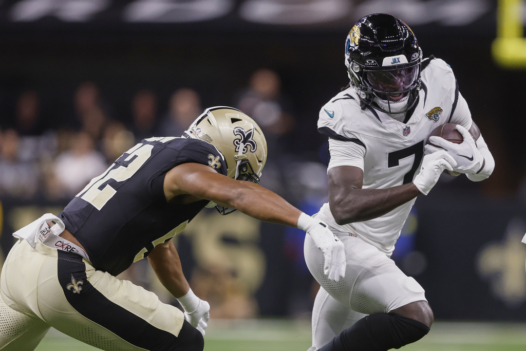 Jacksonville Jaguars wide receiver Brian Thomas Jr. (7) moves to get past New Orleans Saints linebacker D'Marco Jackson, left, in the first half of an NFL preseason football game in New Orleans, Sunday, Aug. 17, 2025. (AP Photo/Butch Dill)