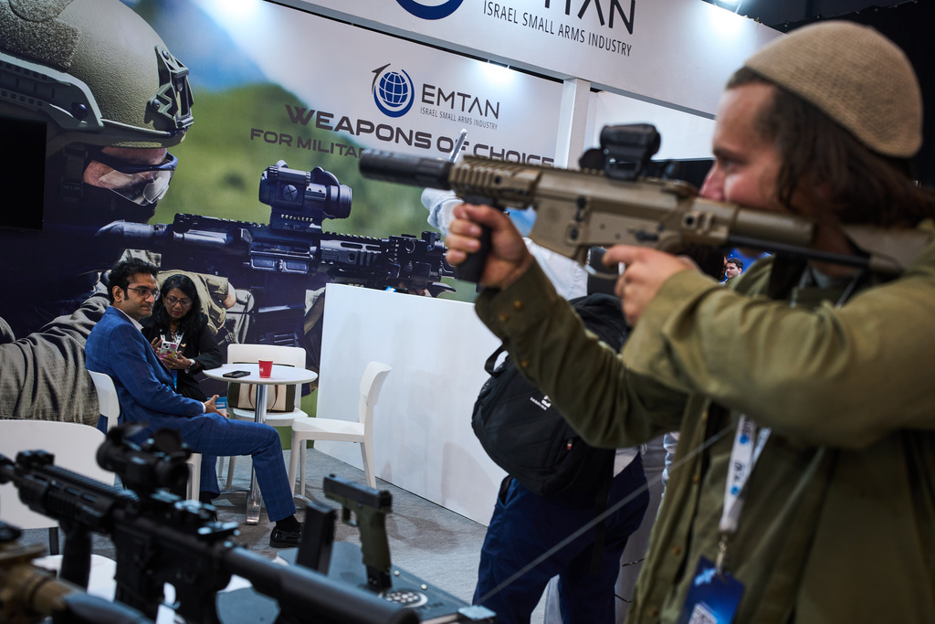 Visitors examine weapons on display at a defense industry exhibition in Tel Aviv, Israel, Tuesday, Feb. 17, 2026. (AP Photo/Oded Balilty)