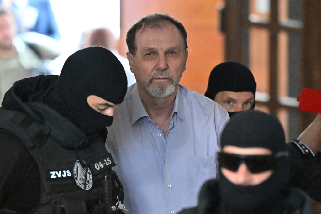 FILE -Juraj Cintula, center, is escorted to the Specialized Criminal Court in Banská Bystrica, Slovakia, July 8, 2025, for a trial over last year's attempted assassination of Slovakia's populist Prime Minister Robert Fico. (Vaclav Salek/CTK via AP, File)