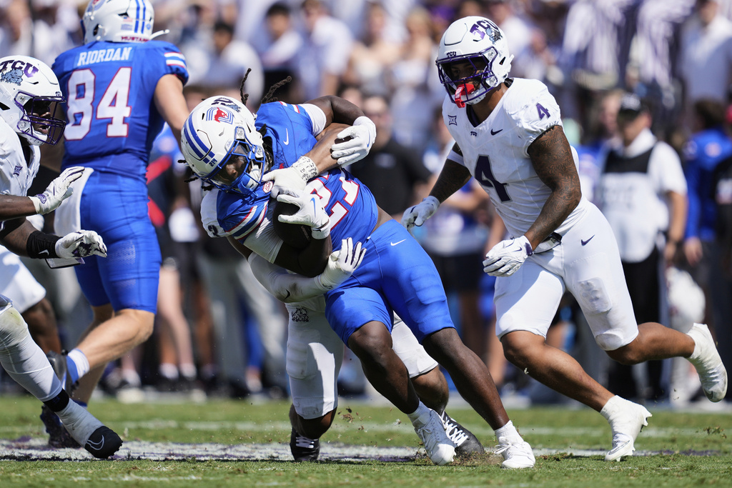 SMU running back Dramekco Green (21) is stopped behind the line of scrimmage by TCU linebacker Kaleb Elarms-Orr, rear, in the first half of an NCAA college football game, Saturday, Sept. 20, 2025, in Fort Worth, Texas. (AP Photo/Tony Gutierrez)
