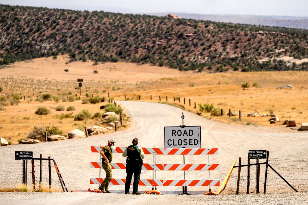 Law enforcement officers staff a roadblock as the Snyder Fire burns near Mack, Colo., on Sunday, June 28, 2026. (AP Photo/Noah Berger)