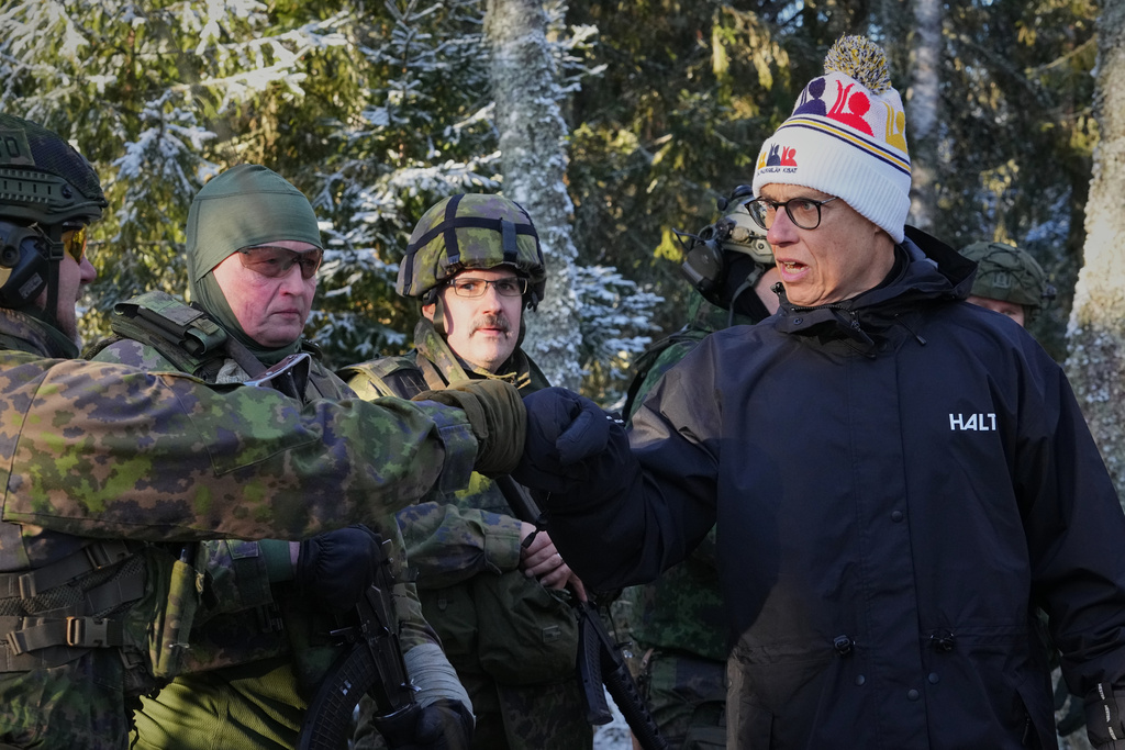 Finland's President Alexander Stubb greets volunteers during a combat rescue exercises organized by the National Defence Training Association of Finland, in Halvala, Finland, Saturday, Nov. 15, 2025. (AP Photo/Sergei Grits)