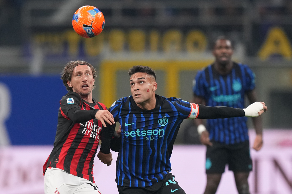 AC Milan's Luka Modric, left, and Inter Milan's Lautaro Martinez fight for the ball during the Serie A soccer match between Inter Milan and AC Milan in Milan, Italy, Sunday, Nov. 23, 2025. (AP Photo/Antonio Calanni)