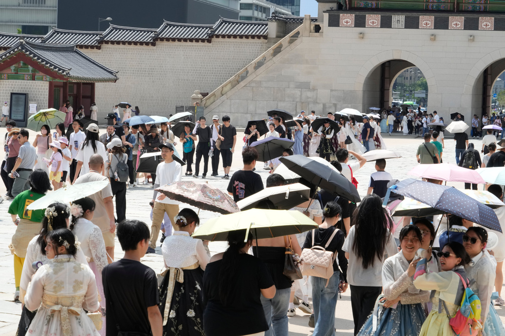 Visitors hold umbrellas to avoid sunshine at the Gyeongbok Palace in Seoul, South Korea, Wednesday, Aug. 5, 2026. (AP Photo/Ahn Young-joon)