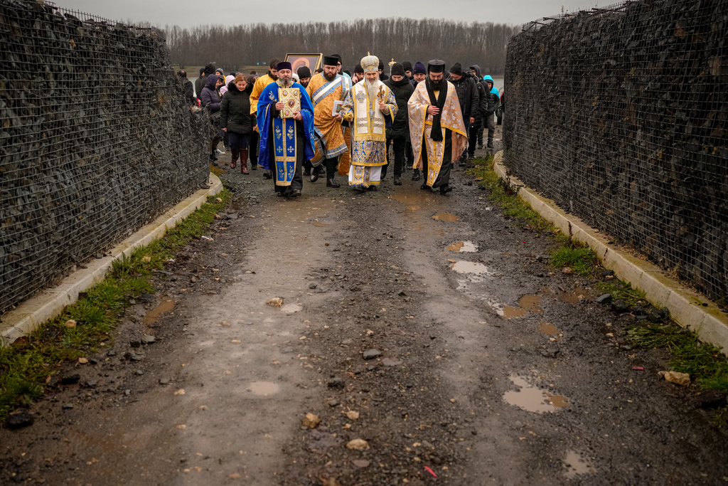 Orthodox archbishop Teodosie, centre, walks with clerics and faithful at the end of a religious service by the river Danube in Harsova, Romania, Monday, Jan. 5, 2026, a day ahead of the celebration of Epiphany. (AP Photo/Vadim Ghirda)