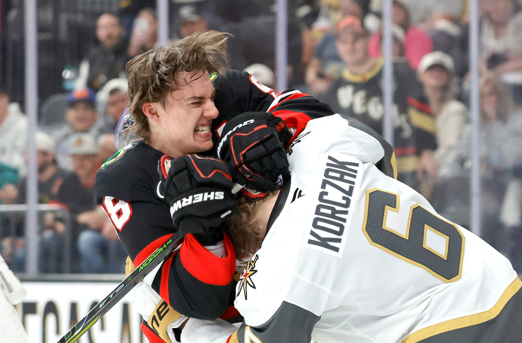 Chicago Blackhawks center Connor Bedard (98) fights with Vegas Golden Knights defenseman Kaedan Korczak (6) during the first period of an NHL hockey game Saturday, March 14, 2026, in Las Vegas. (AP Photo/Steve Marcus)