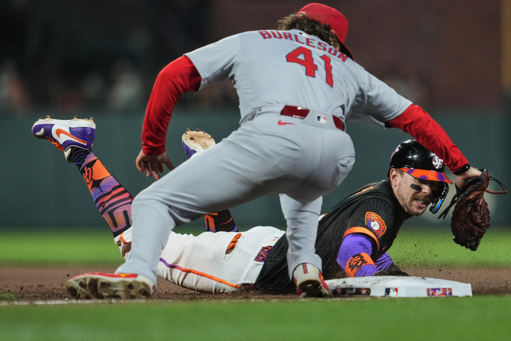 San Francisco Giants' Christian Koss, right, dives back safely at first next to St. Louis Cardinals first baseman Alec Burleson (41) during the fifth inning of a baseball game, Tuesday, Sept. 23, 2025, in San Francisco. (AP Photo/Godofredo A. Vásquez)