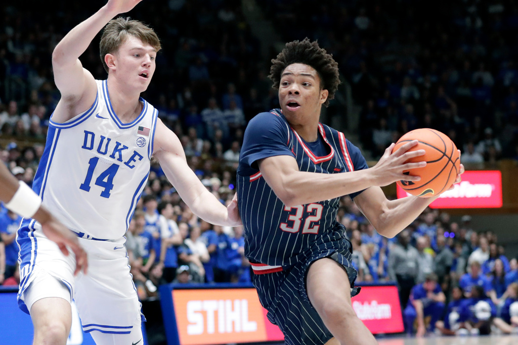 Howard forward Travelle Bryson (32) drives against Duke guard Nikolas Khamenia (14) during the first half of an NCAA college basketball game, Sunday, Nov. 23, 2025, in Durham, N.C. (AP Photo/Chris Seward)