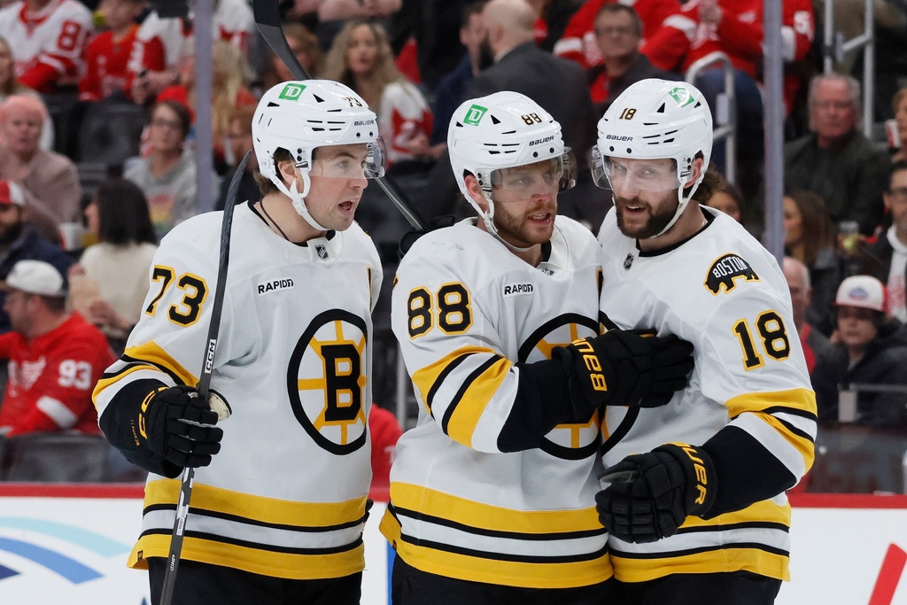 Boston Bruins right wing David Pastrnak (88) celebrates after his goal against the Detroit Red Wings with defenseman Charlie McAvoy (73) and center Pavel Zacha (18) during the second period of an NHL hockey game Saturday, March 21, 2026, in Detroit. (AP Photo/Duane Burleson)