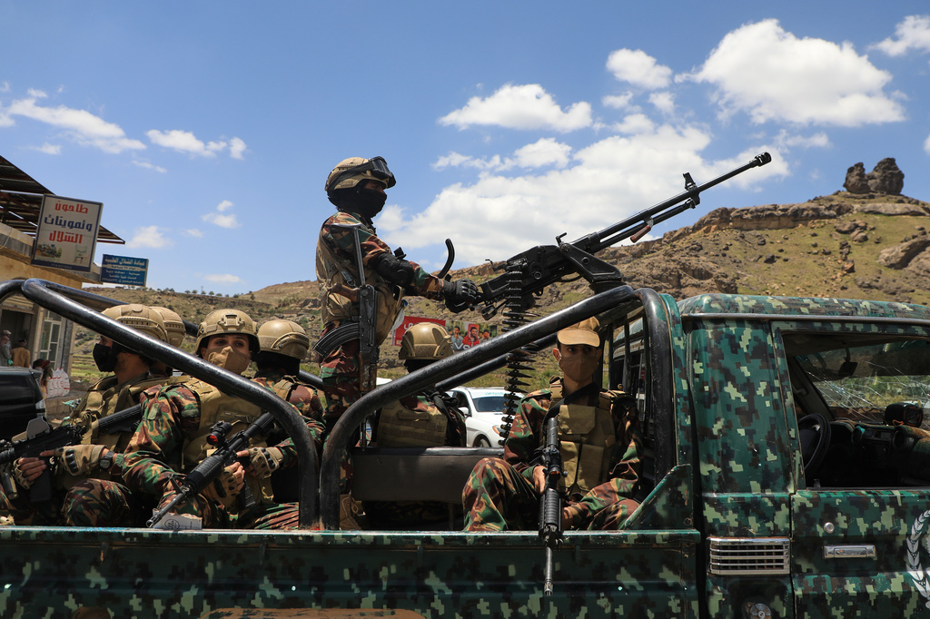 Houthi fighters escort a convoy carrying prisoners freed in Mokha through the Bani Matar district on its way to Sanaa, Yemen, Saturday, Sept. 12, 2026, following the Houthi takeover of the southern Red Sea port city. (AP Photo/STR)