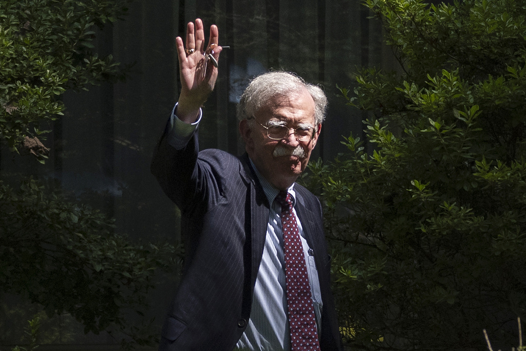Former national security adviser John Bolton waves as he arrives at his house Friday, Aug. 22, 2025, in Bethesda, Md. (AP Photo/Manuel Balce Ceneta)