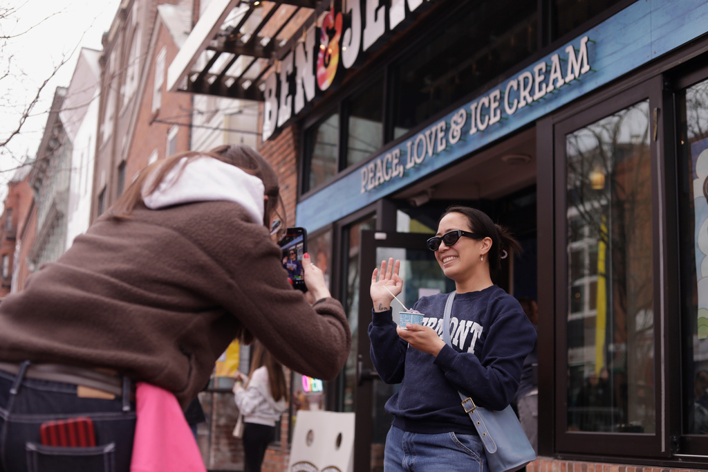 Bettina Guevara poses for a photo with her free serving of ice cream outside the Ben and Jerry's scoop shop on Free Cone Day in Burlington, Vt., Tuesday, April 14, 2026. (AP Photo/Amanda Swinhart)