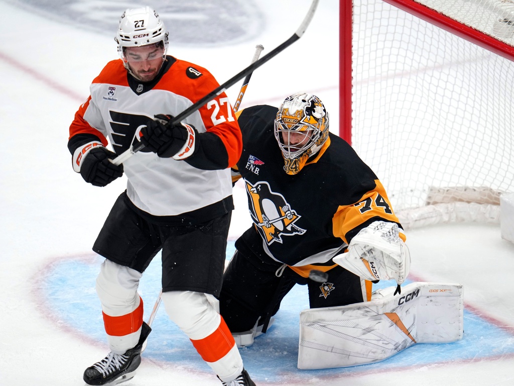 Philadelphia Flyers right wing Owen Tippett (74) blocks a shot while being screened by Philadelphia Flyers' Noah Cates (27) during the first period of an NHL hockey game in Pittsburgh, Saturday, March 7, 2026. (AP Photo/Gene J. Puskar)
