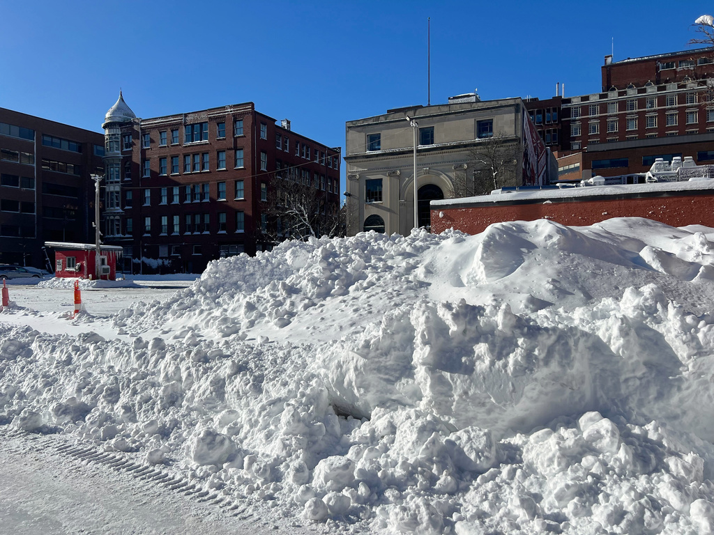 Snow is piled high along a side street Tuesday, Feb. 24, 2026, in Providence, R.I. (AP Photo/Kimberlee Kruesi)