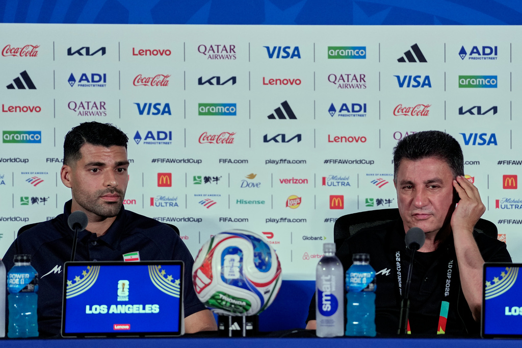Iran head coach Amir Ghalehnoy, right, and player Mehdi Taremi listens to a question during a press conference ahead of their FIFA World Cup match against New Zealand in Inglewood, Calif., near Los Angeles, Sunday, June 14, 2026. (AP Photo/Andre Penner)