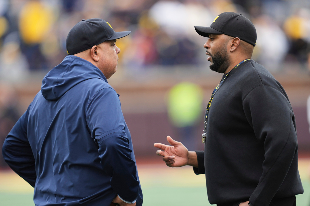 FILE - Michigan athletic director Warde Manuel, left, talks with head coach Sherrone Moore, right, before an NCAA college football spring game in Ann Arbor, Mich., April 19, 2025. (AP Photo/Paul Sancya, file)
