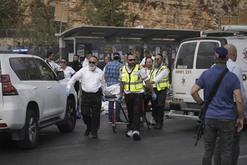 Israeli Zaka rescue and recovery team carry the body of a victim at the scene of shooting attack carried out by two Palestinian gunmen, in which several people were killed and others injured at a bus stop in Jerusalem, Monday, Sept. 8, 2025. (AP Photo/Mahmoud Illean)