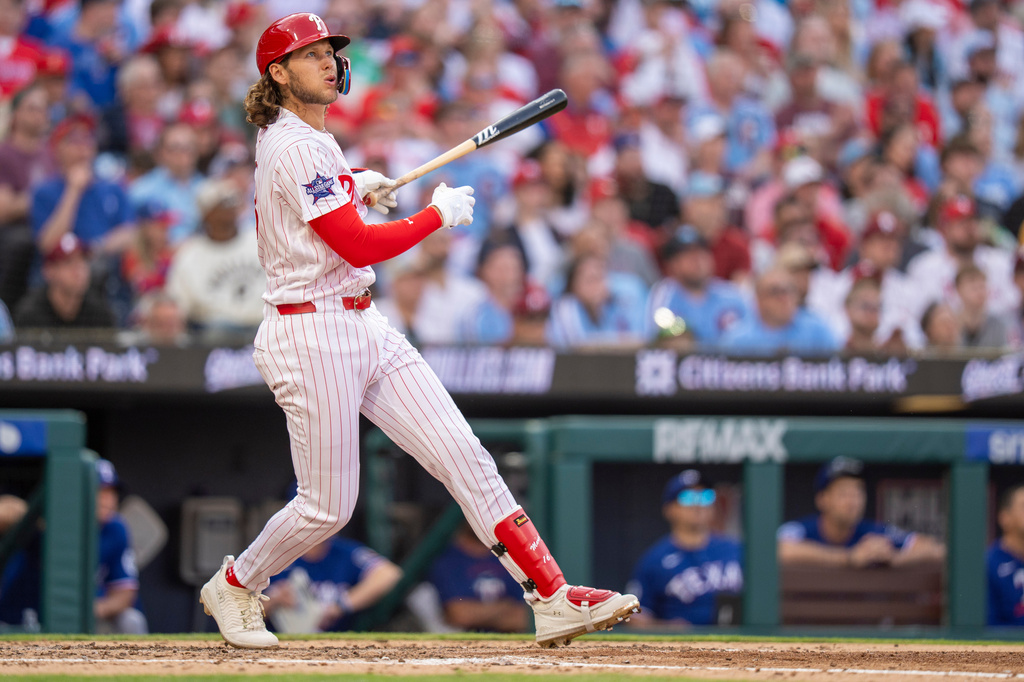 Philadelphia Phillies' Alec Bohm hits a three-run home rum during the fifth inning of an opening-day baseball game against the Texas Rangers, Thursday, March 26, 2026, in Philadelphia. (AP Photo/Chris Szagola)